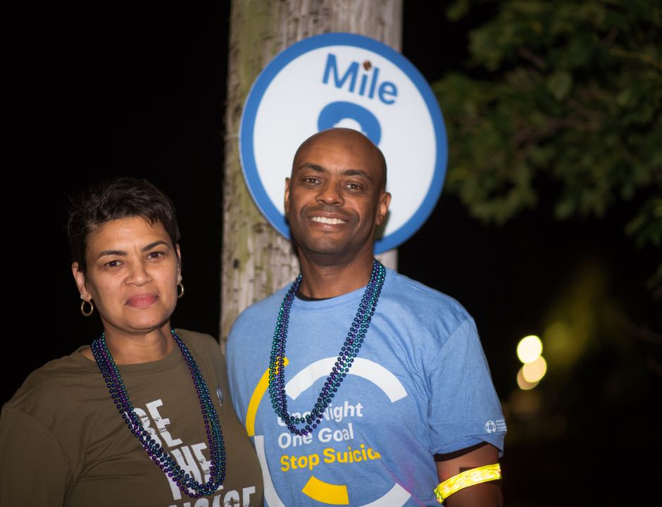 Man and woman in front of mile marker